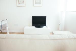 桑坦德Estilo nordico Sardinero的客厅配有白色桌子上的电视