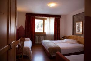 科戈洛Baita Scaia的酒店客房设有两张床和窗户。