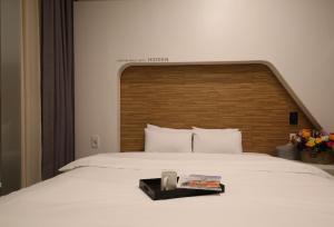 光州Urban Stay Hotel的卧室配有一张白色大床和木制床头板