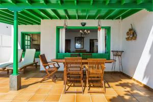 宏达海滩Casajardin的庭院设有一张桌子和椅子,拥有绿色的天花板