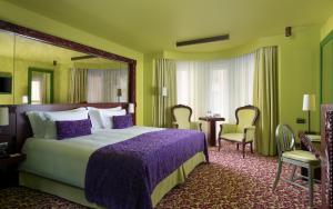 圣彼得堡多米纳圣彼得堡酒店的酒店客房带一张床、一张桌子和椅子