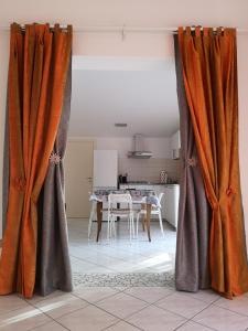 切尔维亚Sul Confine的客厅配有橙色窗帘和桌子