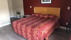 艾尔蒙特Aqua Inn Motel的一间卧室配有一张大床和红色的被子