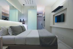 里约热内卢Nobile Hotel Copacabana Design的一间卧室配有一张床,墙上配有电视