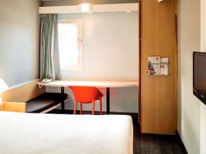 迪耶普迪耶普宜必思乐瓦都瑞尔酒店的小房间设有桌子和红色椅子