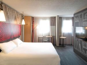 里摩日利摩日北宜必思酒店的一间酒店客房,配有白色的床和电视