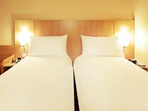 讷穆尔宜必思内穆尔斯酒店的配有2张床铺的酒店客房,提供白色床单和枕头