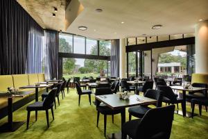 布里斯班伊顿山酒店的餐厅设有桌椅和大窗户。