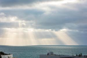 珀斯维特罗布鲁士嘉堡海滩华美达酒店的太阳照耀着云朵的海洋景象