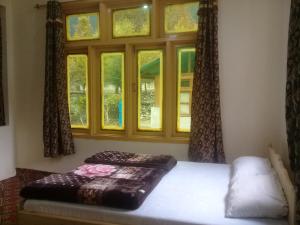 Benazir Hotel Kalash的一间卧室设有一张床和一个窗口