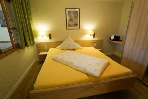 比赫莱尔塔尔Appartementhotel Breitmattstub的一间卧室配有黄色的床和两个枕头