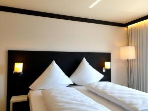 伊勒蒂森ILL Hotel by WMM Hotels的一间卧室配有两张带白色床单和枕头的床。