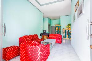 武吉丁宜OYO 2903 Putri Residence Syariah的一间设有红色椅子和桌子的房间