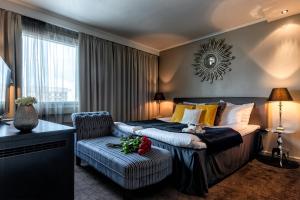罗瓦涅米北极城市酒店的配有一张床和一把椅子的酒店客房