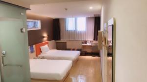 重庆7天优品重庆江北国际机场回兴轻轨站的酒店客房配有两张床和一张书桌