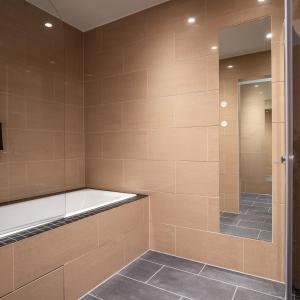 加勒穆恩松恩会议酒店的浴室配有步入式淋浴和浴缸