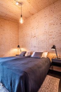 米湖Aska, Modern Cabin的卧室配有一张木墙内的大床