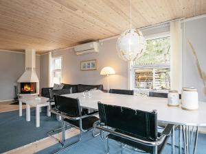 博托比Three-Bedroom Holiday home in Væggerløse 6的客厅配有桌椅和壁炉