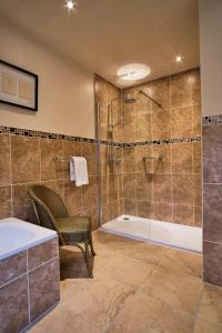 Loch Awe基尔亨公寓的带淋浴和浴缸的浴室以及椅子