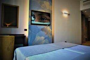米兰莫肯巴国王酒店的卧室配有一张床,并有一幅眼睛的照片