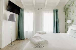 科拉迪拉齐塞CASA BACI - Soggiorno nel Gusto的卧室配有白色床和平面电视