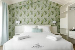 科拉迪拉齐塞CASA BACI - Soggiorno nel Gusto的一间卧室配有一张白色的床和绿色的墙壁