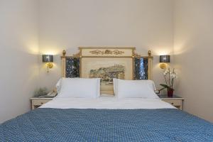 佛罗伦萨多纳泰罗酒店的一张带两个白色枕头和蓝色毯子的床