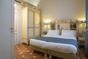 佛罗伦萨多纳泰罗酒店的一间卧室配有一张大床和木制床头板