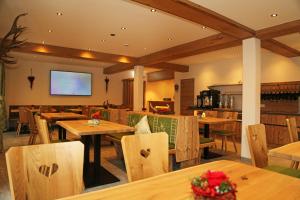 恩斯塔尔豪斯施密布奇度假屋的餐厅设有木桌、椅子和屏幕