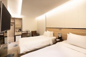 新加坡The Quay Hotel的一间酒店客房,设有两张床和电视