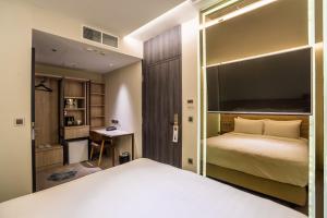 新加坡The Quay Hotel的一间卧室配有一张大床和一张书桌