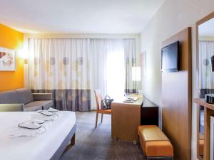 里斯本里斯本诺富特酒店的酒店客房设有床和客厅。