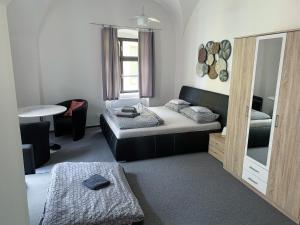 因德日赫城堡Penzion Měšťan的客房设有两张床、一张桌子和镜子