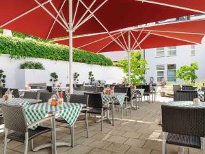 慕尼黑慕尼黑城北宜必思酒店的户外庭院配有桌椅和遮阳伞。