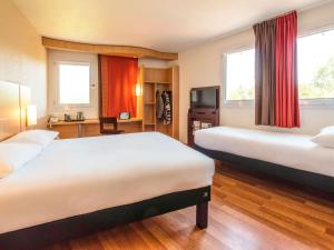 马恩河畔埃索姆蒂耶里堡宜必思酒店的酒店客房设有两张床和电视。