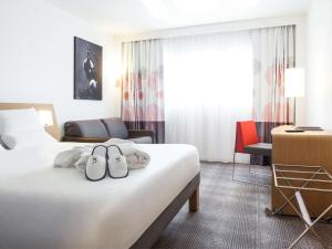 马尼·莱斯·阿莫Novotel Saint-Quentin en Yvelines的酒店客房的床上配有2条毛巾