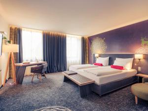 慕尼黑慕尼黑市中心美居酒店的酒店客房设有一张大床和一张书桌。