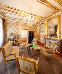 卢森堡Hotel Le Place d'Armes - Relais & Châteaux的客厅配有家具和吊灯。