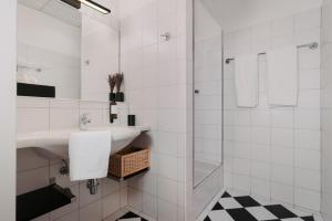 格蒙登Hotel Esplanade的白色的浴室设有水槽和淋浴。