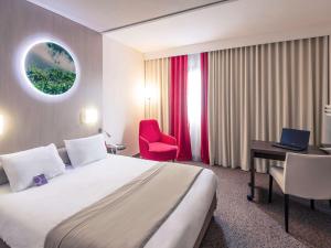 尼奥尔尼奥尔马莱波特温美居酒店的酒店客房配有一张床、一张书桌和一台笔记本电脑
