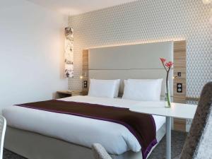 朗吉斯巴黎奥利朗吉斯机场美居酒店的酒店客房设有一张大床和一张桌子。