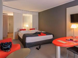 美因河畔法兰克福弗兰克福特展览中心美居酒店的酒店客房设有一张大床和一张桌子。