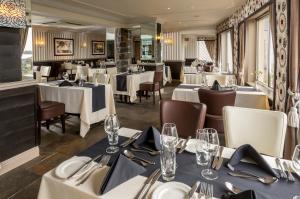 卡斯特科博湾酒店的用餐室配有白色桌椅和桌子。