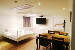 釜山山坡酒店的一间卧室配有一张床、一张桌子和一张婴儿床。