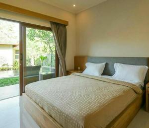 库塔阿尔纳亚民宿的一间卧室设有一张大床和一个大窗户