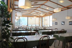 松本中之汤温泉传统日式旅馆的用餐室配有桌椅和大窗户
