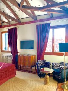威尼斯拉卡尔西纳酒店的一间卧室配有一张床、两把椅子和一台电视