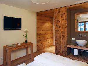 萨尔察赫河畔戈灵斯塔勒贺夫酒店的一间卧室配有一张床、一台电视和一个水槽