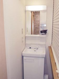 大阪幸运经济型酒店的白色的浴室设有水槽和镜子