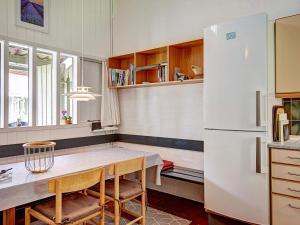 阿灵厄7 person holiday home in Allinge的厨房配有桌子和白色冰箱。